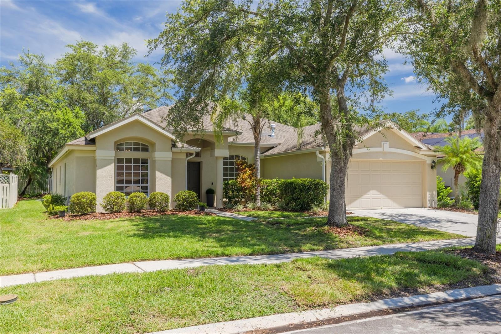 Welcome home to this stunning Hunter's Green sanctuary with its grand arched entrance and elegant columns creating an impressive first impression. The refreshed tropical landscaping featuring vibrant bromeliads and mature palms perfectly frames this beautiful home.