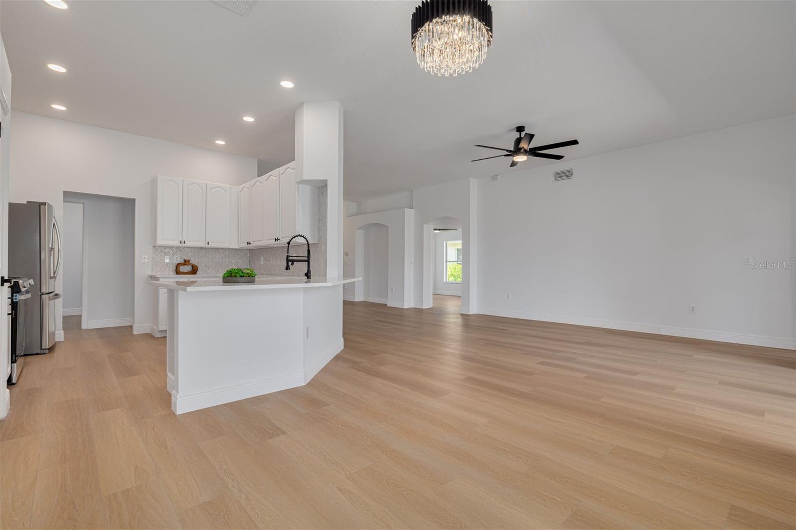 The spectacular open concept design allows for effortless entertaining while the kitchen island serves as the perfect gathering spot. Two stunning chandeliers define each space while maintaining the cohesive flow that makes this home so special.