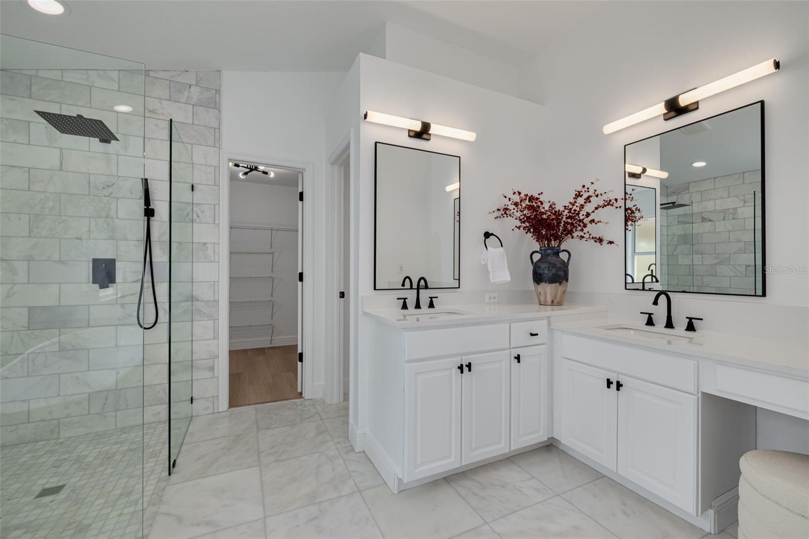 Transform your daily routine in this spa-like master bathroom featuring stunning marble and dual vanities with beautiful quartz countertops. The modern lighting and premium fixtures create a resort-style experience right at home.