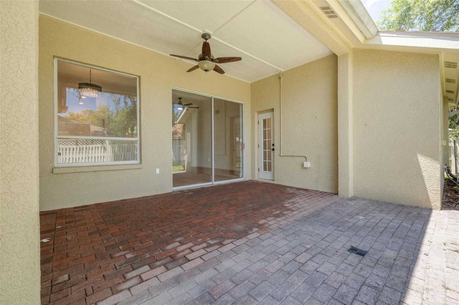 Embrace the Florida lifestyle on this spacious covered lanai featuring beautiful paver flooring and ceiling fan for year-round comfort. The seamless indoor-outdoor flow makes this the perfect space for morning coffee, evening relaxation, or entertaining guests.