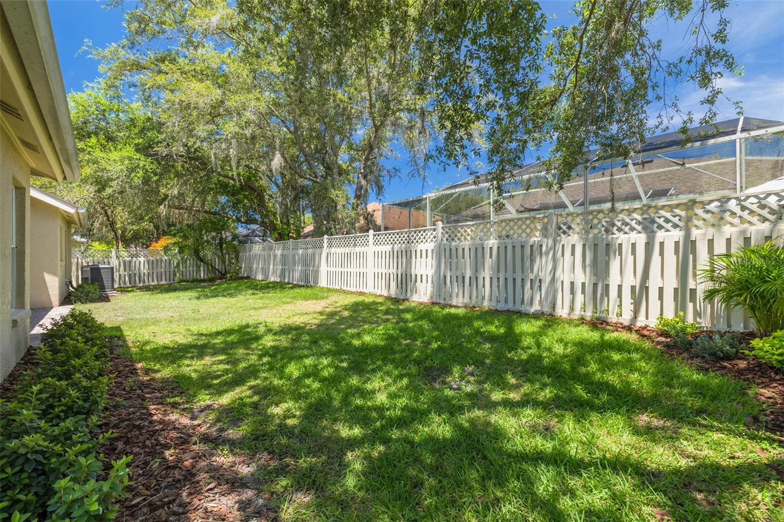 Enjoy the natural beauty and cooling shade of magnificent mature trees that frame this private backyard oasis. The lush landscaping and established greenery create a serene environment that feels like your own personal park.