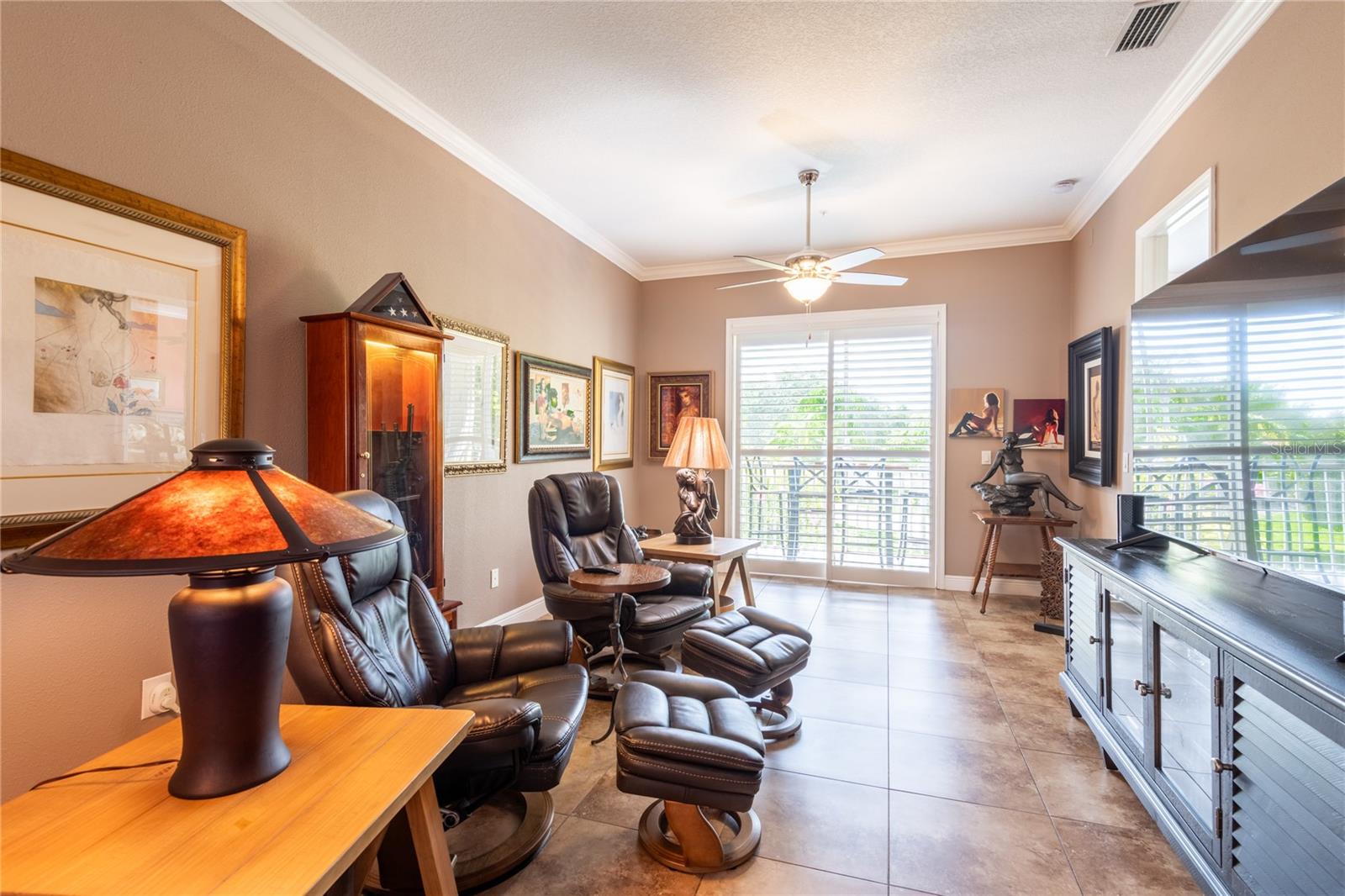 Living room with sliding glass doors in far back to the screen lanai.