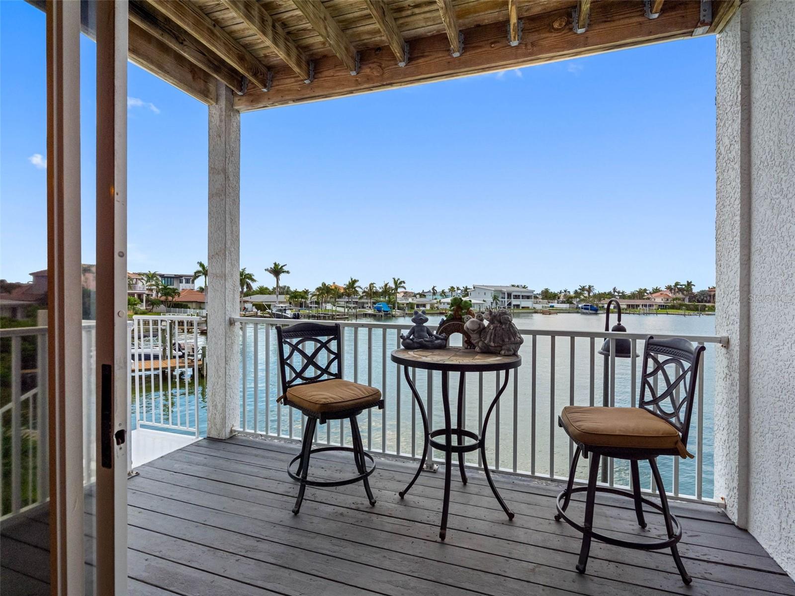 porch off of living area with stair case to lower waterfront area