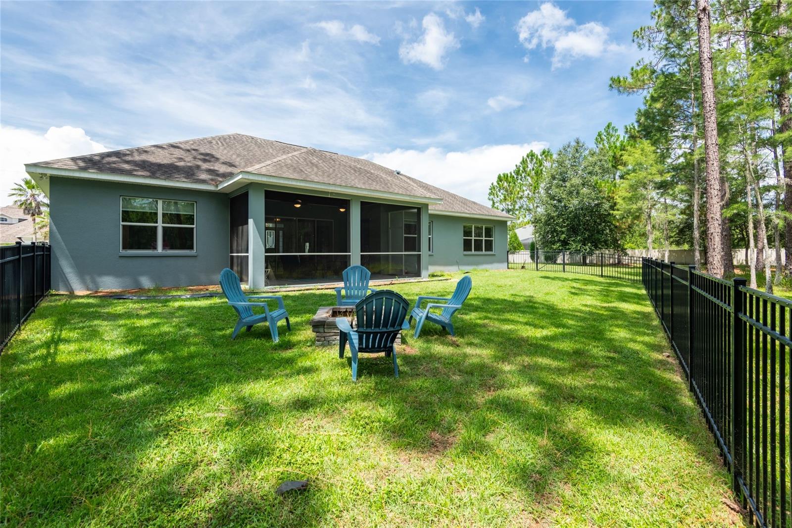 Fenced in backyard with fire pit.