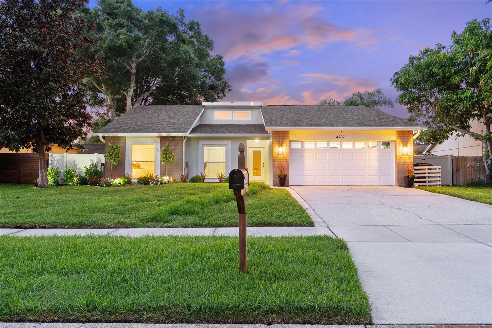 Sunset Front exterior , home sits up elevated from street with 2 car garage