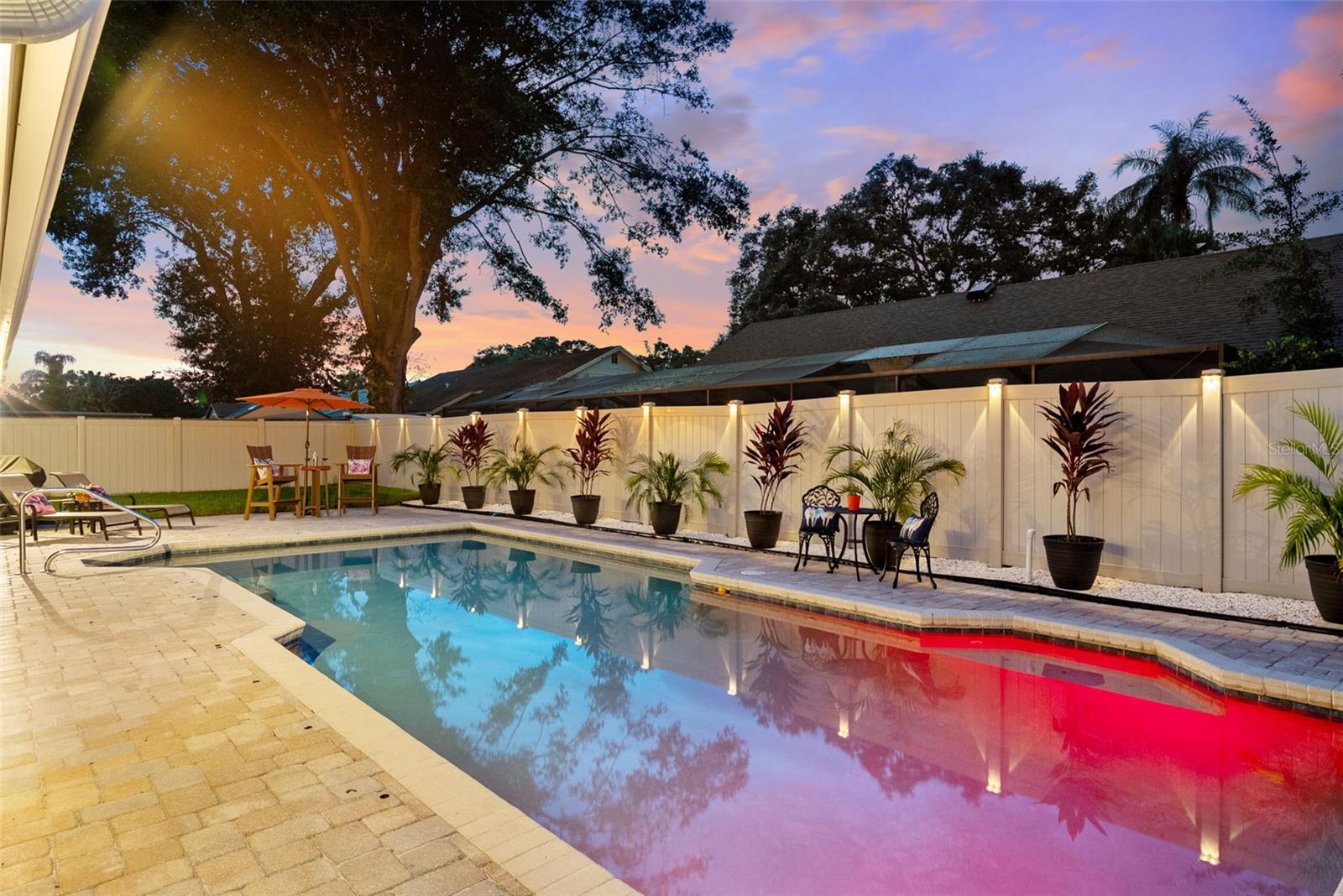 Custom lighting on Fench, pool, exterior of home and trees .