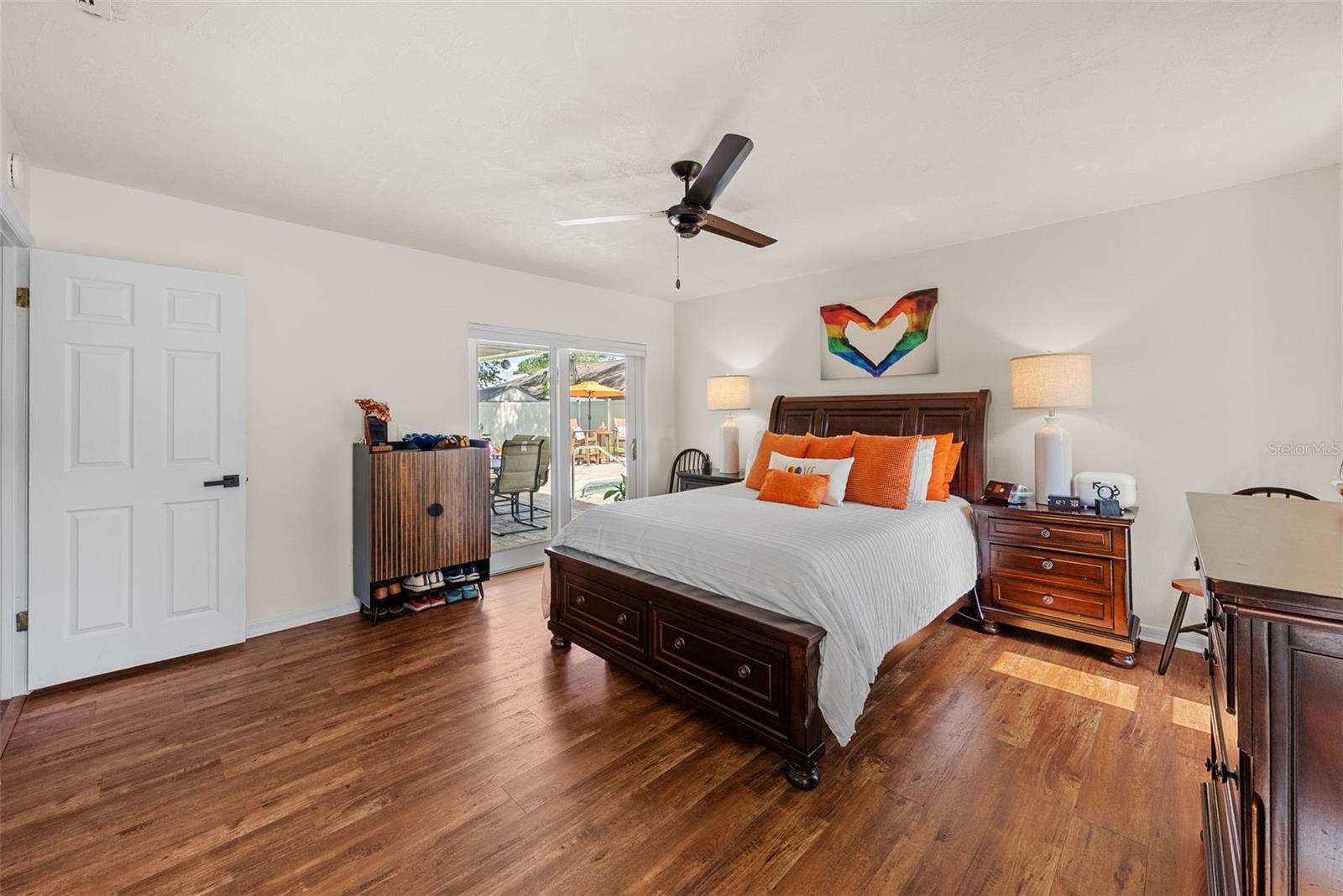 Primary en-suite. Features luxury vinyl flooring New 2025 and French doors leading to pool custom pulldown shades on all windows