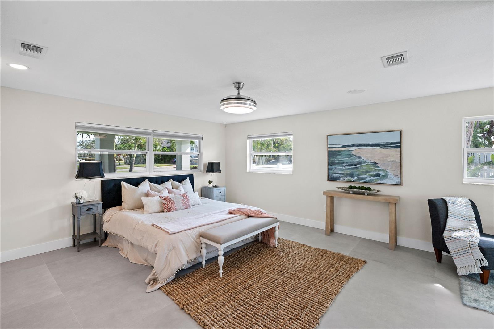 Spacious primary suite with pool and water views