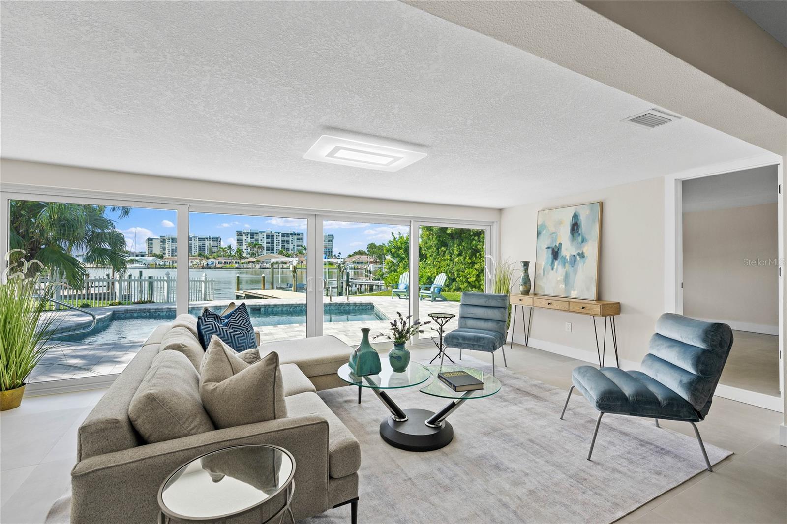Open-concept living with floor-to-ceiling water-facing sliders.