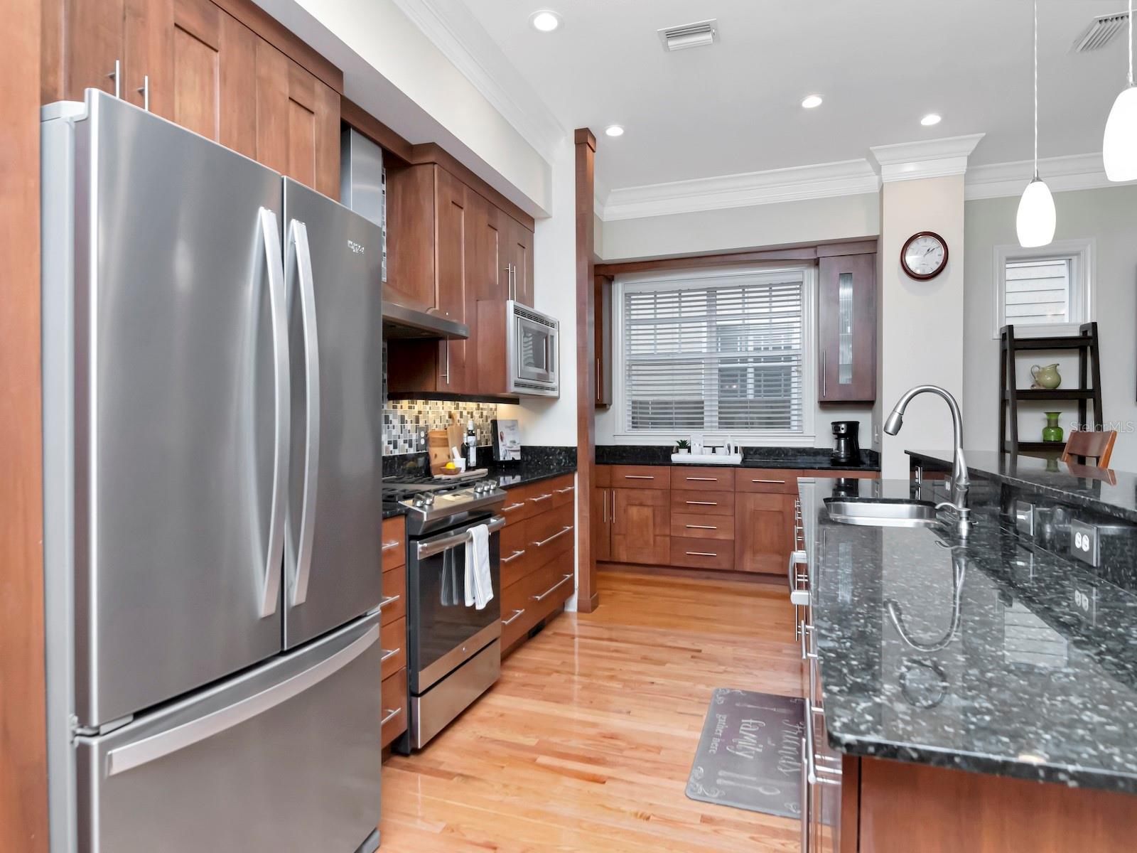 Stainless appliances and rich wood cabinets.
