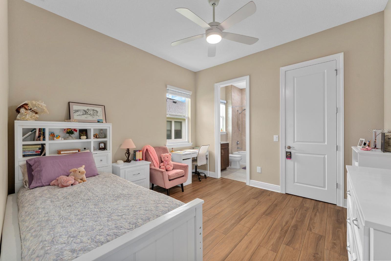 Bedroom 2 with ensuite bathroom features high-end LVP flooring and a walk-in closet, and a lighted ceiling fan with remote.