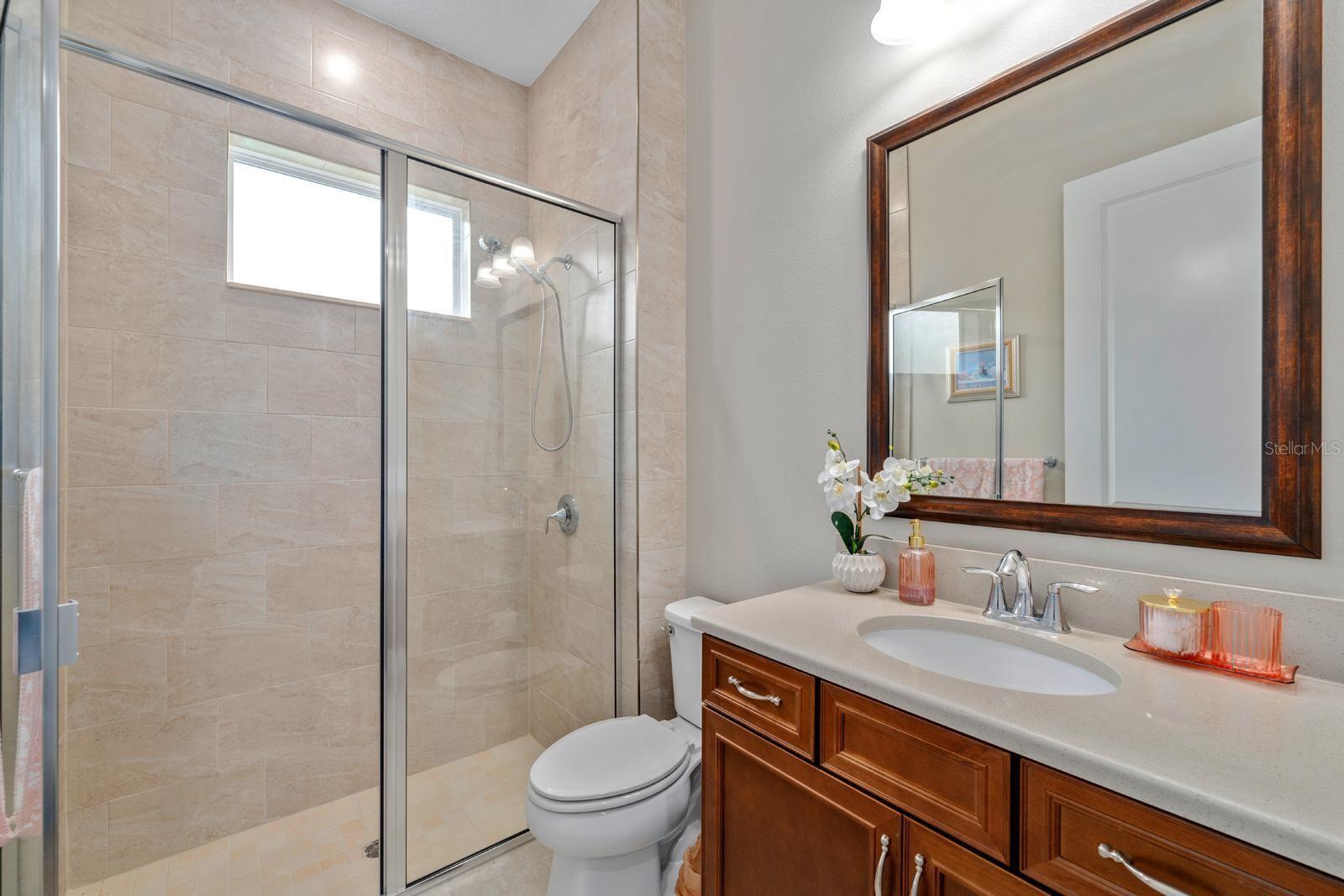 This full bathroom with walk-in shower doubles as the pool bathroom too.