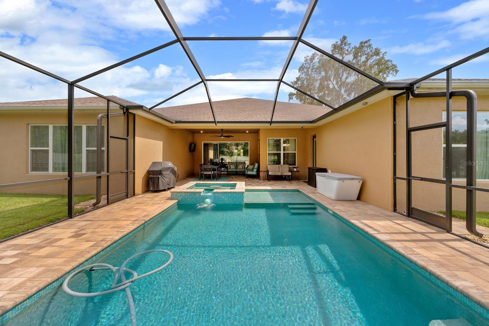 This huge, custom-designed, saltwater pool has a pebble-tec bottom, a sunshelf for little kids or bigger kids, unique teal, iridescent, mosaic tiles, and comes with all of the pool equipment.  The jacuzzi spa is such a luxury too!