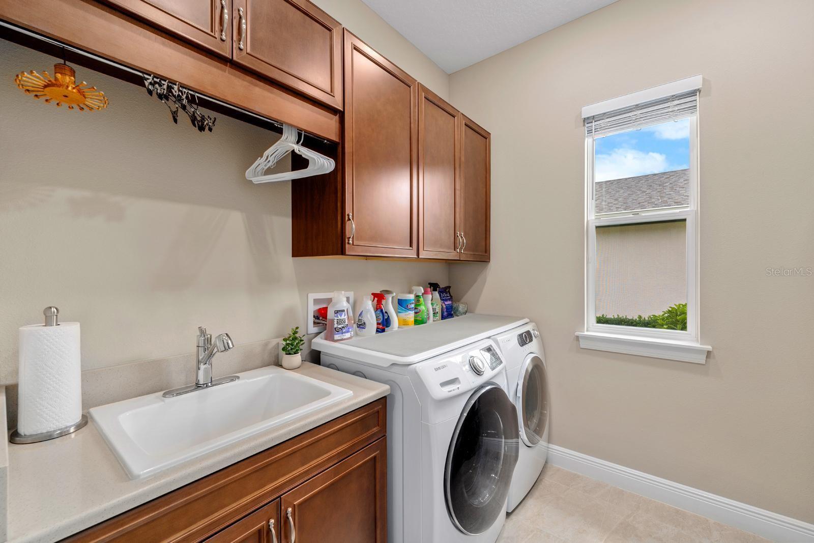 The laundry room features A LOT of storage, as well as a utility sink and two separate areas for hang-up clothes.