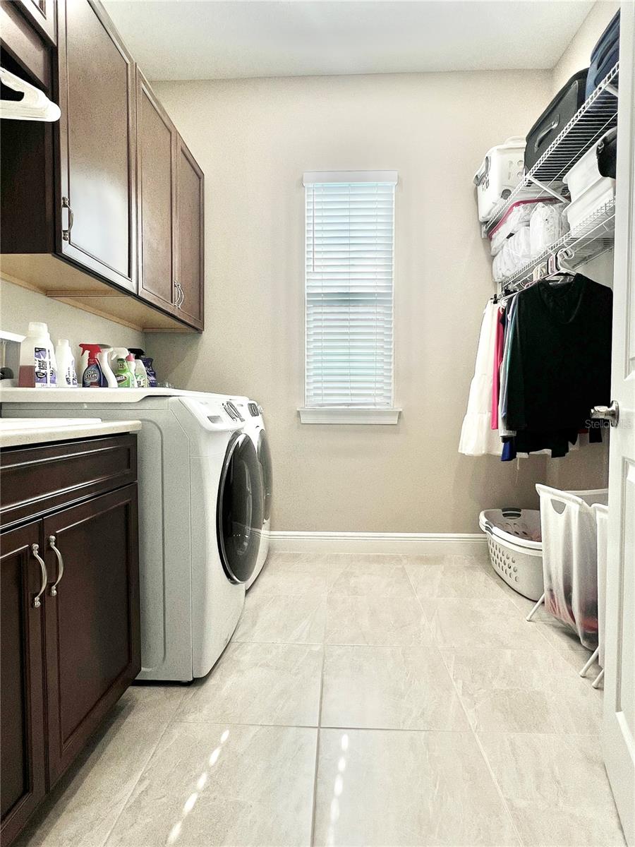 The laundry room features A LOT of storage, as well as a utility sink and two separate areas for hang-up clothes.