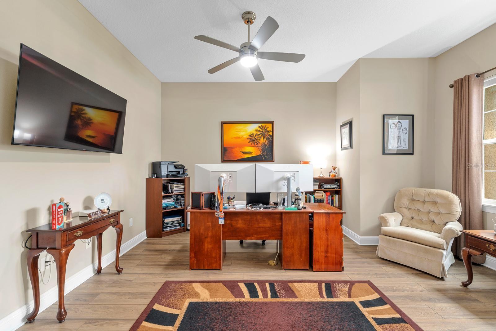 The office is located just inside the front door and features an in floor outlet and a lighted ceiling fan with remote.