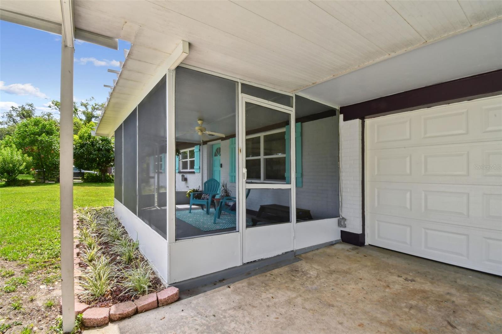 Front screened porch with ceiling fan and garage
