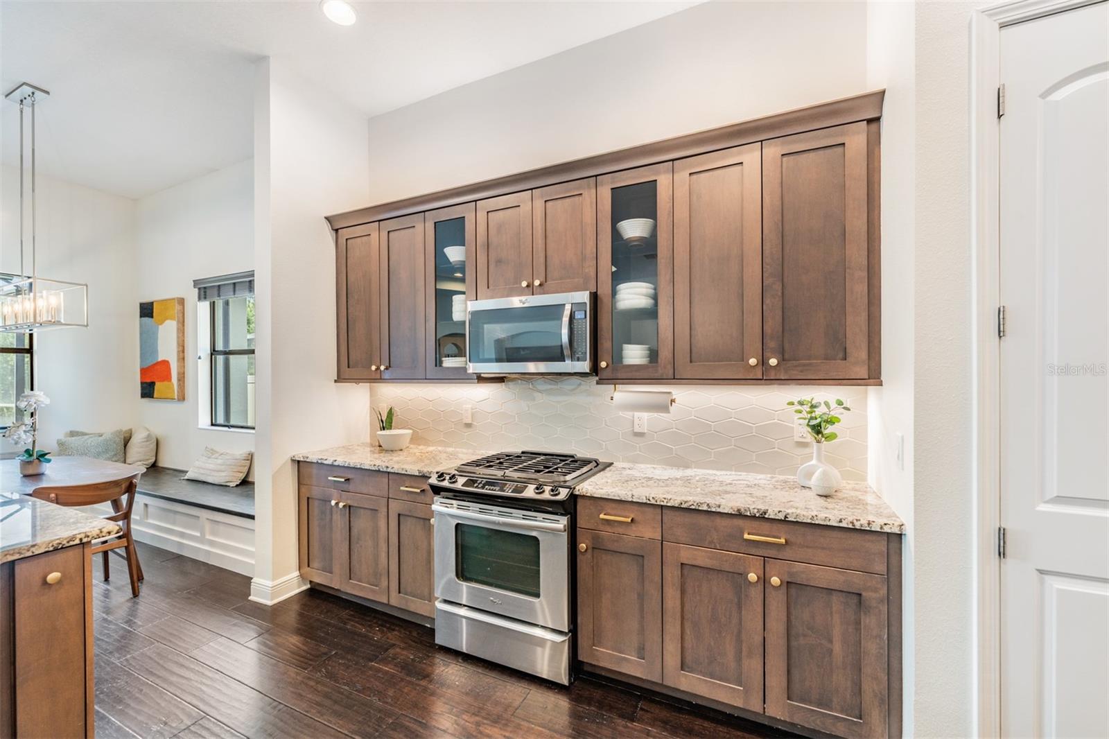 Accented with glass-front cabinets, stone countertops and all stainless appliances