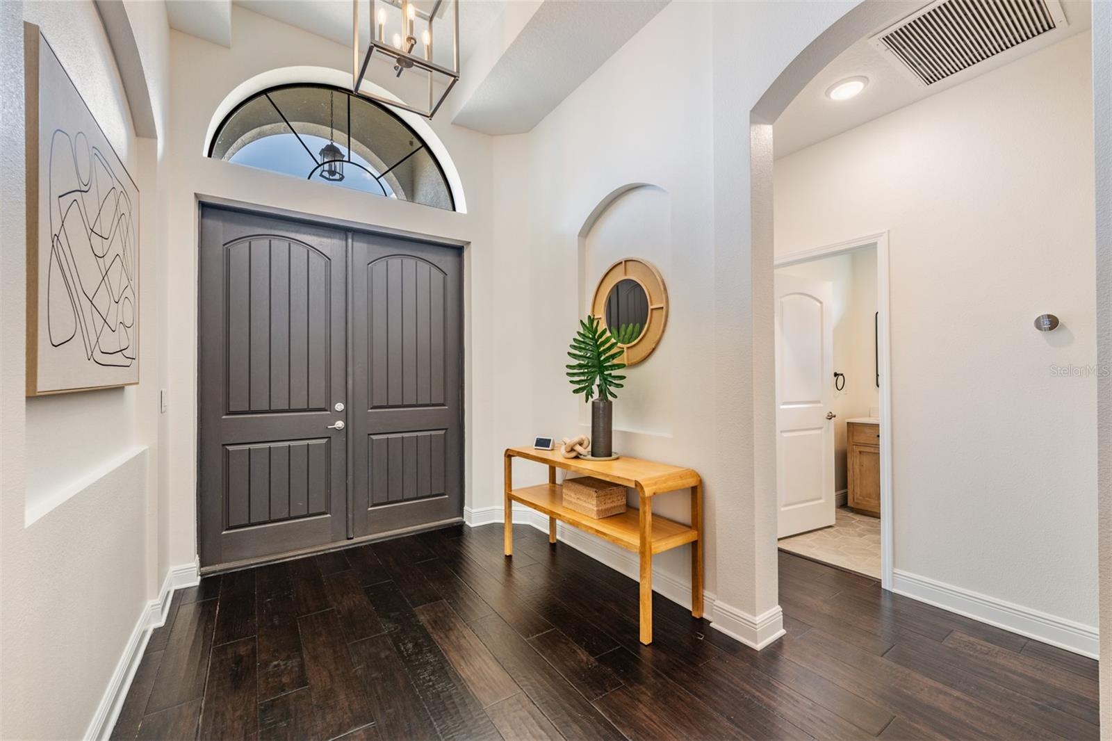High ceiling foyer with custom lighting throughout