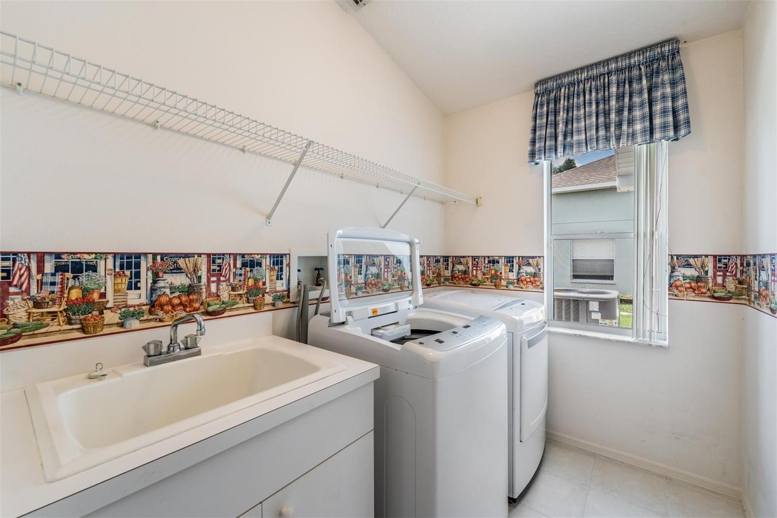 Walk-in laundry room with utility sink and windows