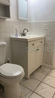 Side view of your bathroom with updated sleek decorative marble tile look, modern cabinet and fixtures to create happy mornings