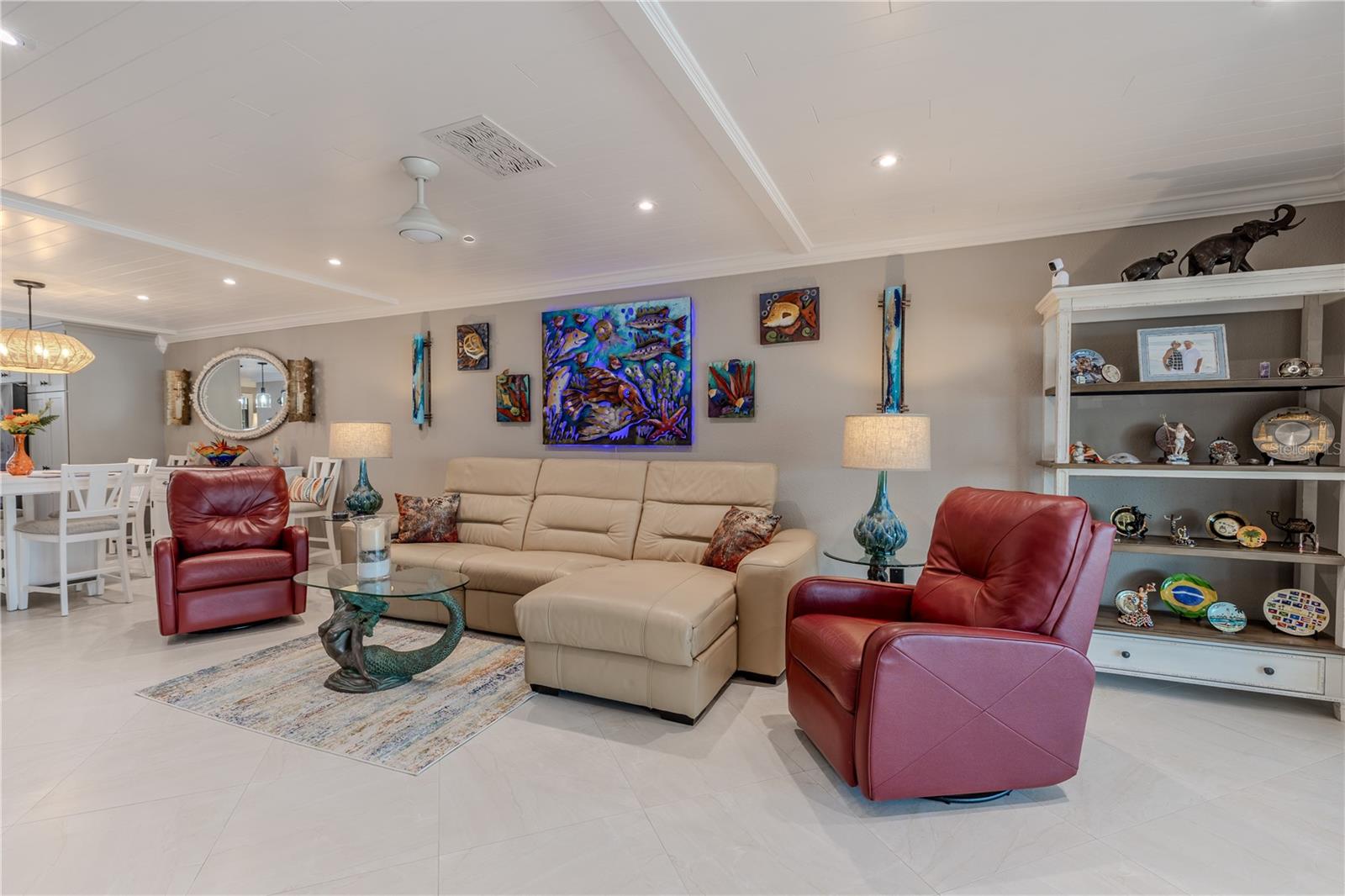 This beautifully maintained living space features a fresh, neutral color palette and large-format porcelain tile flooring laid on the diagonal for a seamless, upscale look. Recessed LED lighting and shiplap ceiling with crown molding add character and brightness throughout. The thoughtful, cohesive design allows for easy personalization and effortlessly complements a variety of styles—making this home truly move-in ready with no updates needed.