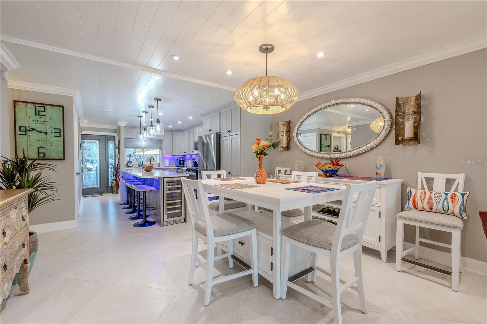 The dining area is spacious and well-lit, featuring six recessed LED can lights on dimmer control for fully adjustable illumination. A statement chandelier from the Luca Collection is centered overhead, offering a warm and stylish focal point.