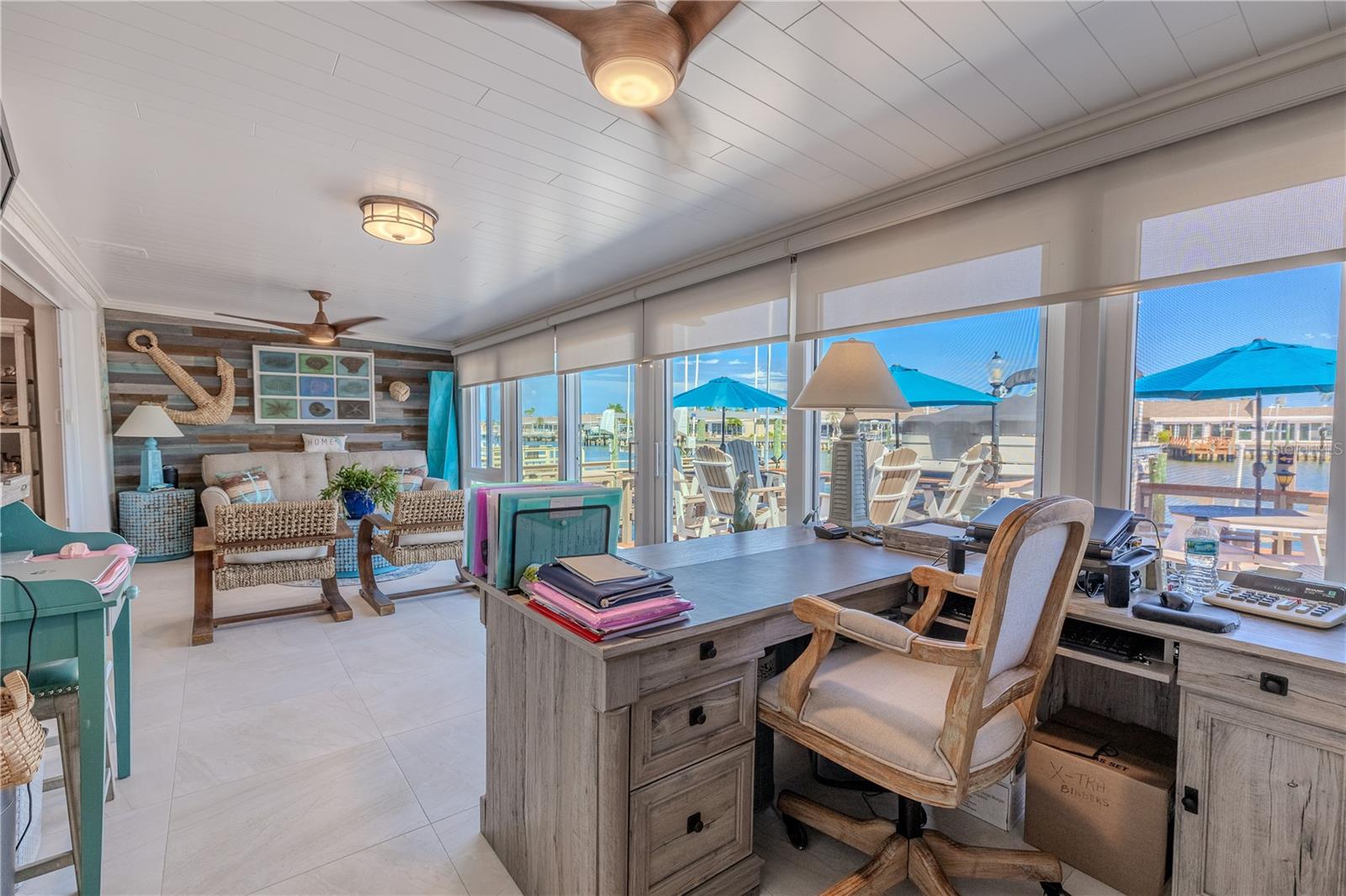 This fully enclosed Florida room is designed for comfort and durability, featuring two stylish Minka Kona Wood ceiling fans with remote controls.