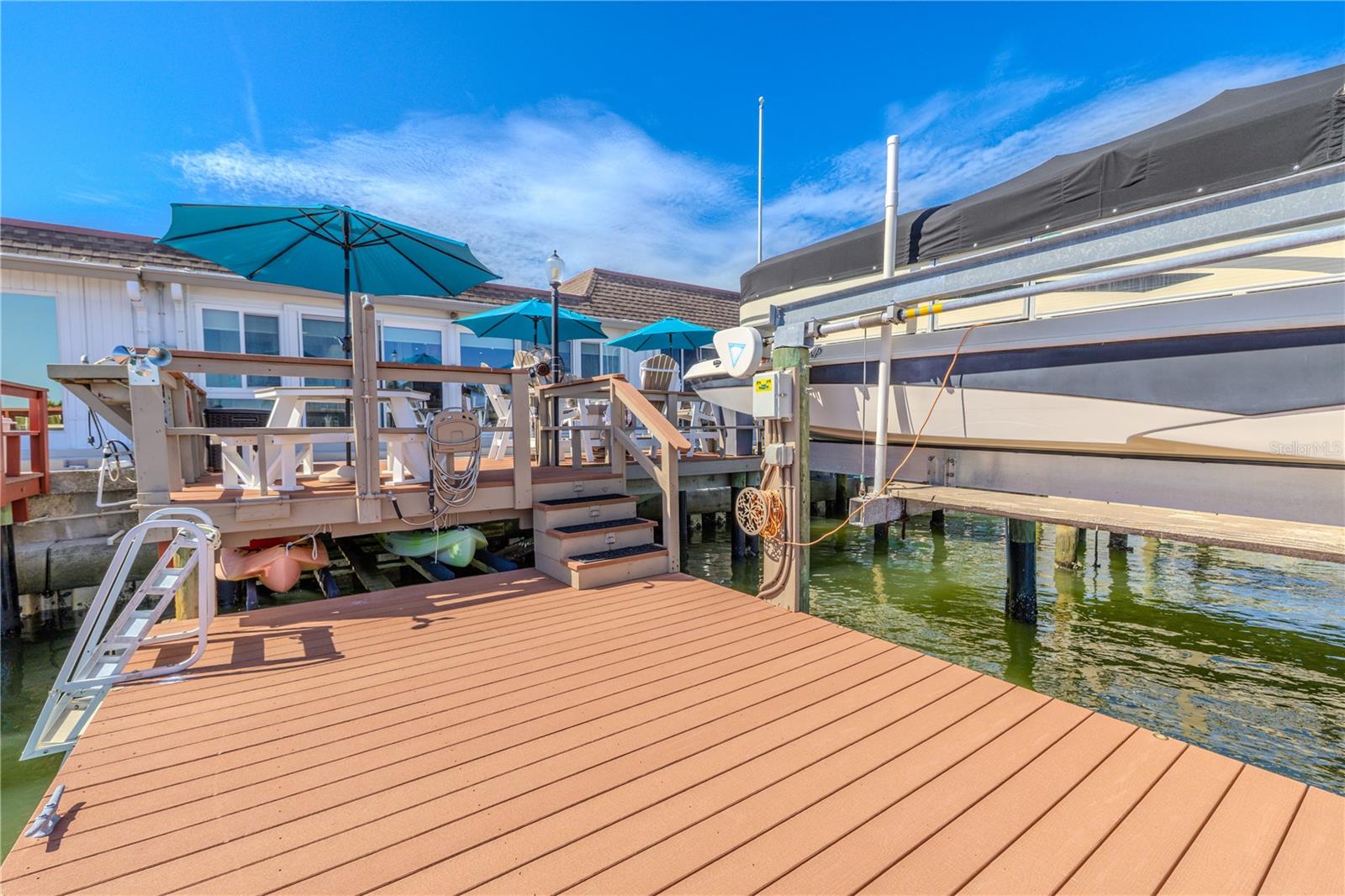The Polywood lower dock offers durable, low-maintenance access to the water, complete with a 6,000 lb. Deco boat lift operated by remote control for added convenience. A custom-built kayak rack is neatly tucked below the upper deck, and the floating dock is ready for a jet ski or other watercraft. Additional features include flat roof tie-downs for security, as well as a built-in outdoor counter and sink—perfect for prepping gear or cleaning the day’s catch. This thoughtfully designed waterfront setup is ideal for boating, paddling, and embracing the coastal lifestyle.