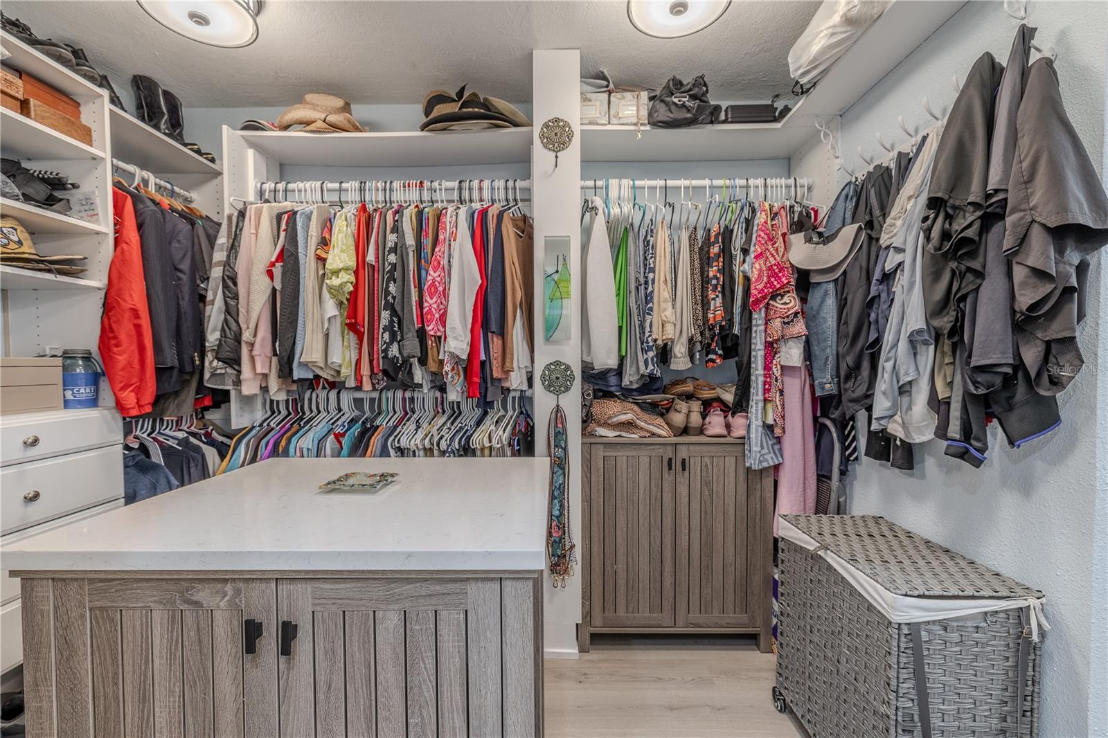 This thoughtfully designed walk-in closet offers both space and function, featuring custom built-in shelving, drawers, and double hanging rods for optimal organization.