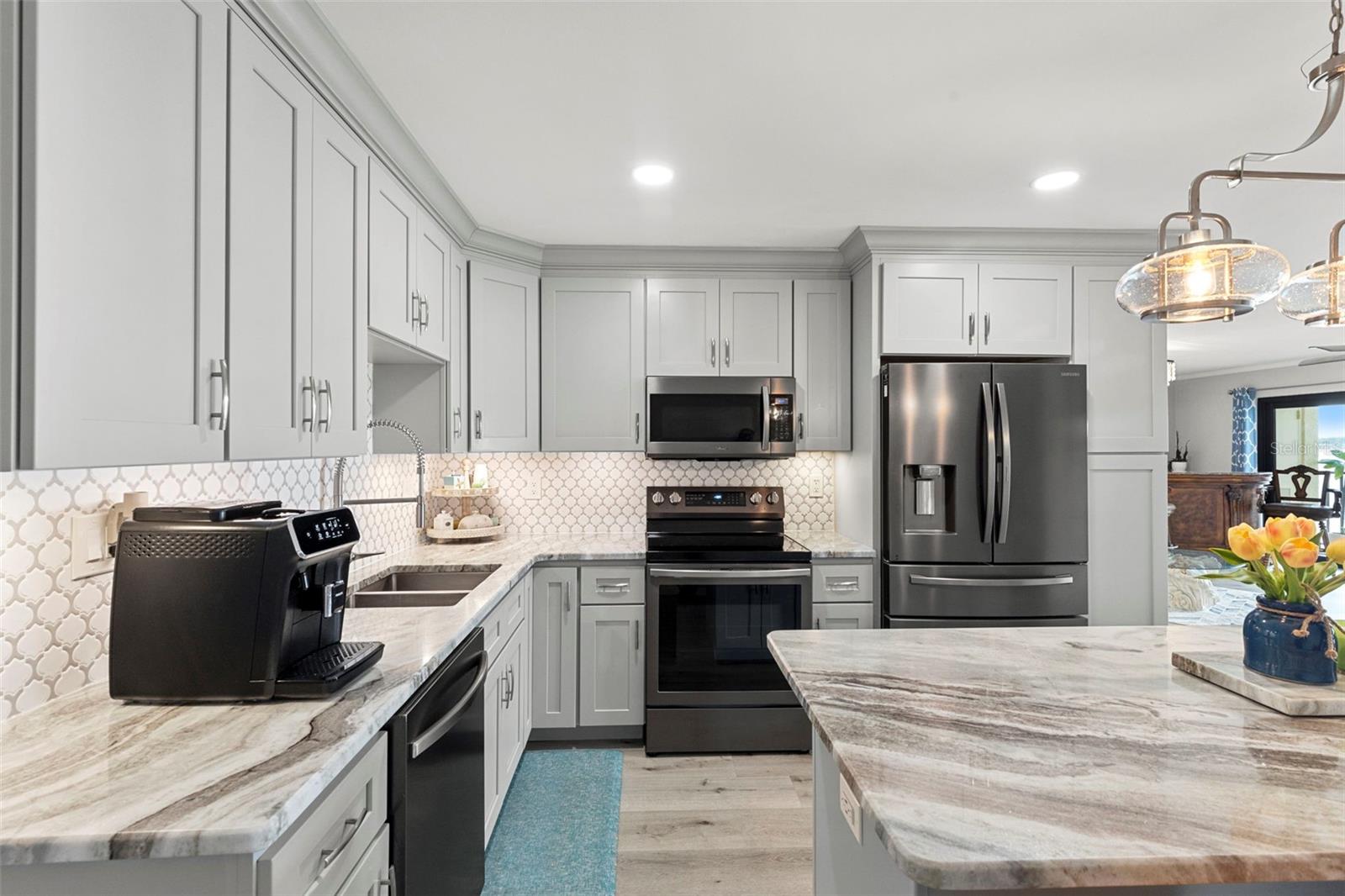 Completely  Remodeled kitchen with quartzite countertops,  artisan backsplash and modern stainless steel appliances.