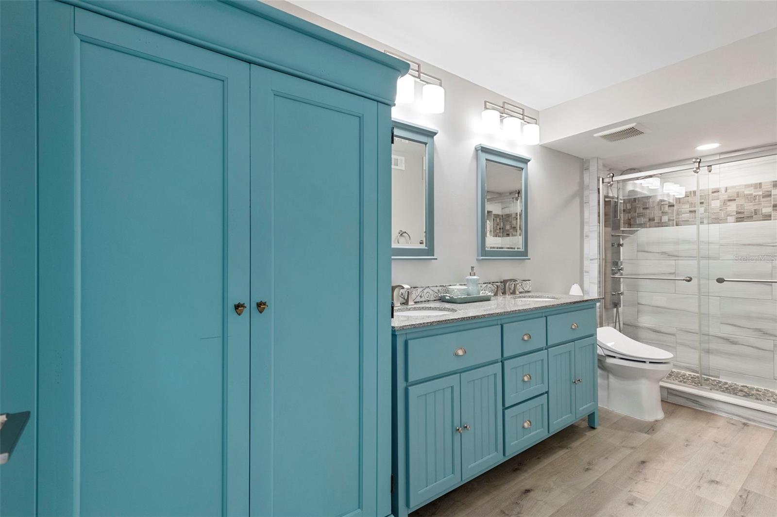 Primary Spa Like Ensuite Bathroom with double sinks, large walk-in shower with glass doors.