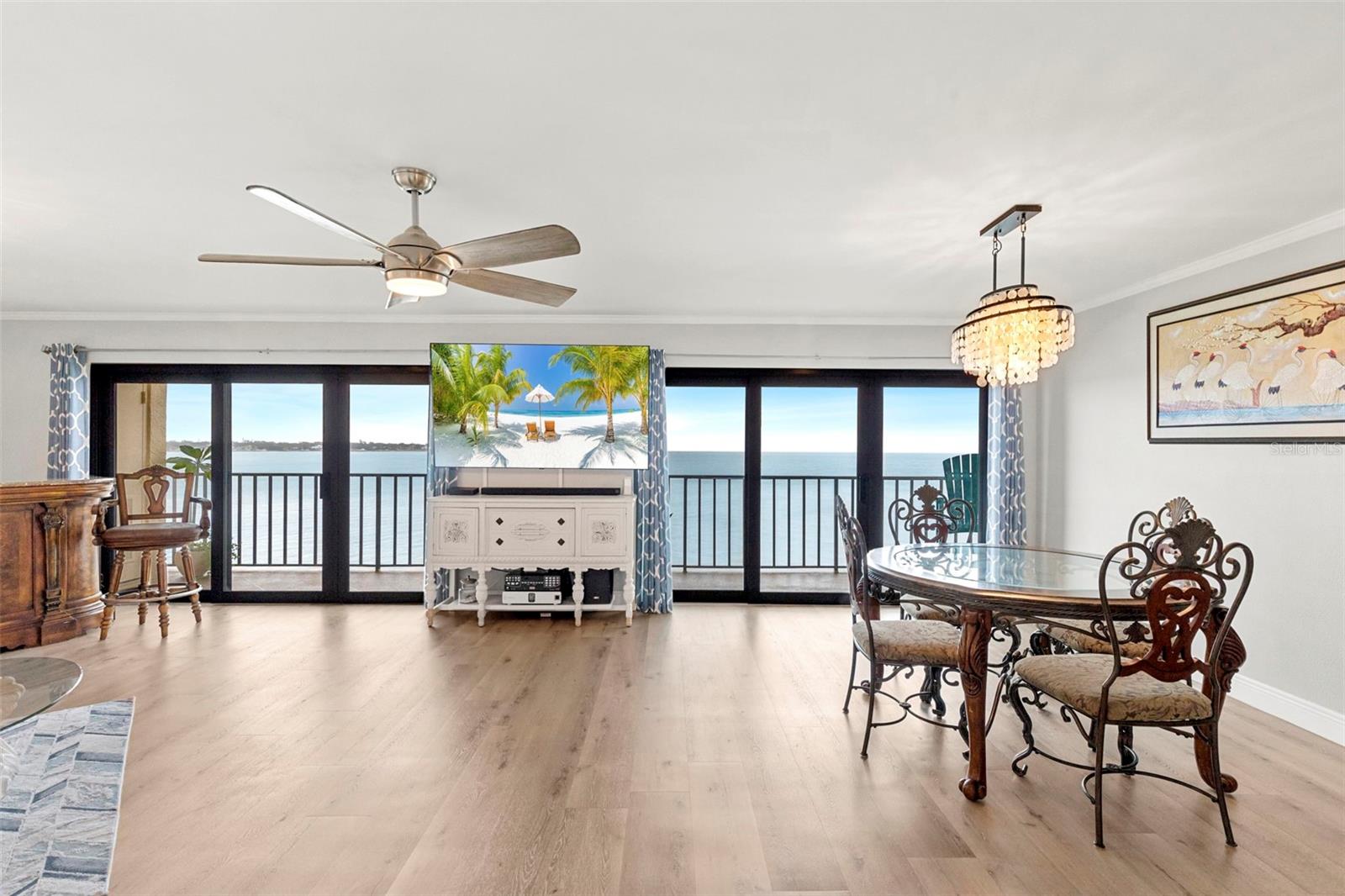 Expansive open-concept living area with stunning water views from every angle and brand new Hurricane impact slider windows to balcony