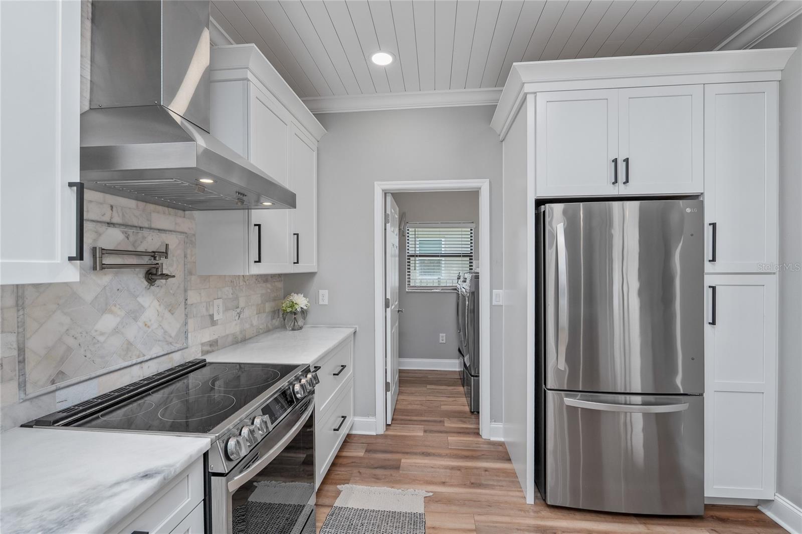 Marble tile backsplash and a pot filler