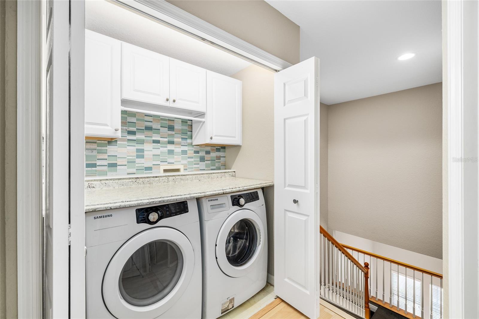 Laundry is located outside of the two primary bedrooms, and has plenty of counter space and cabinets to make doing laundry a breeze