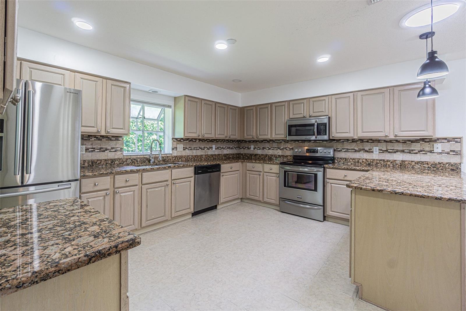 Spacious kitchen with Granite counters and wood cabinets