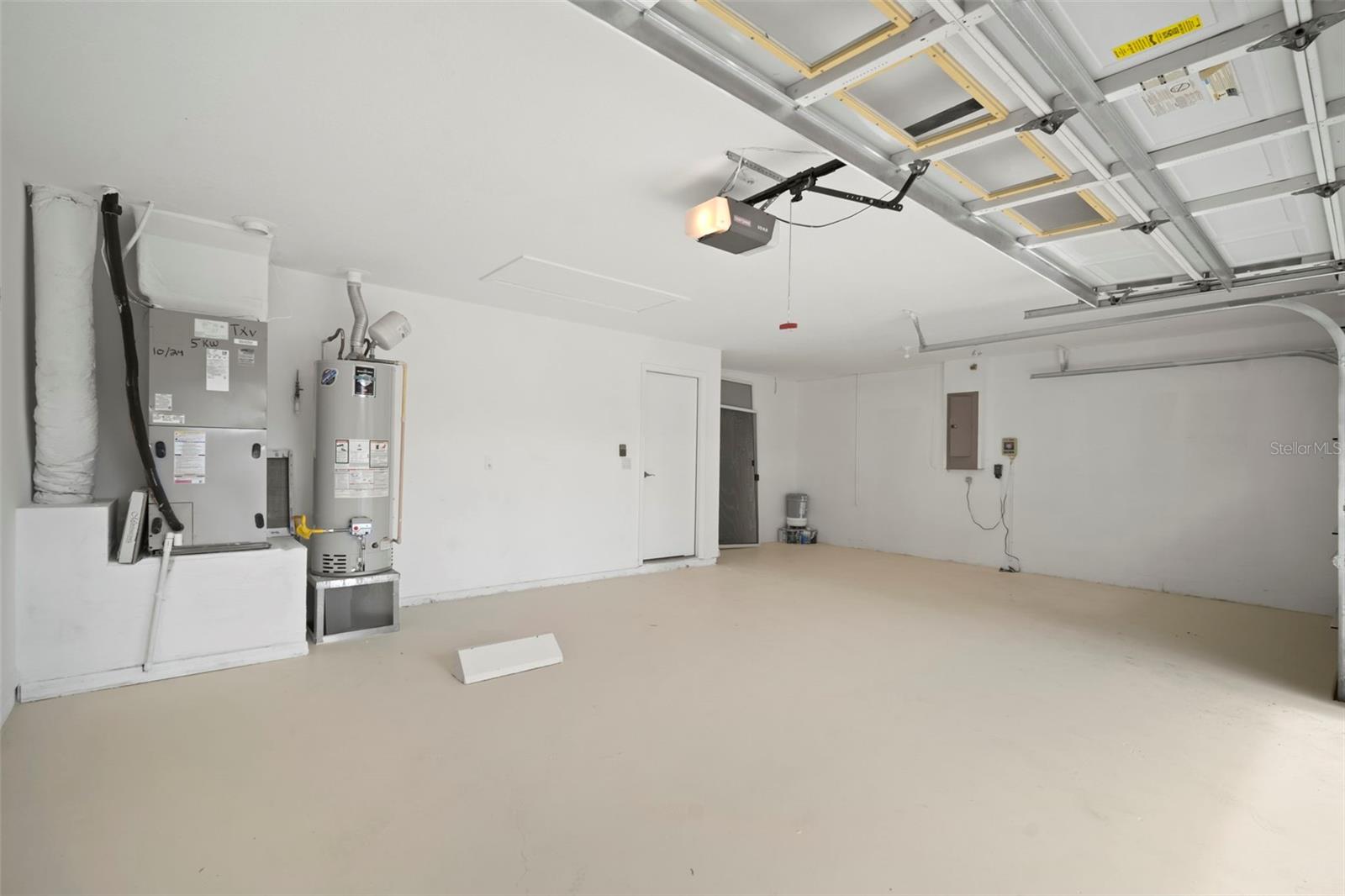 Garage with freshly painted floor, gas hot water heater & newer hvac