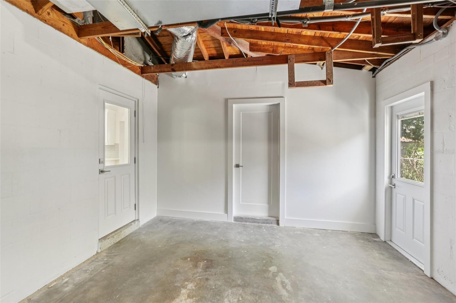 Garage with doors to Kitchen, Laundry, and Outside