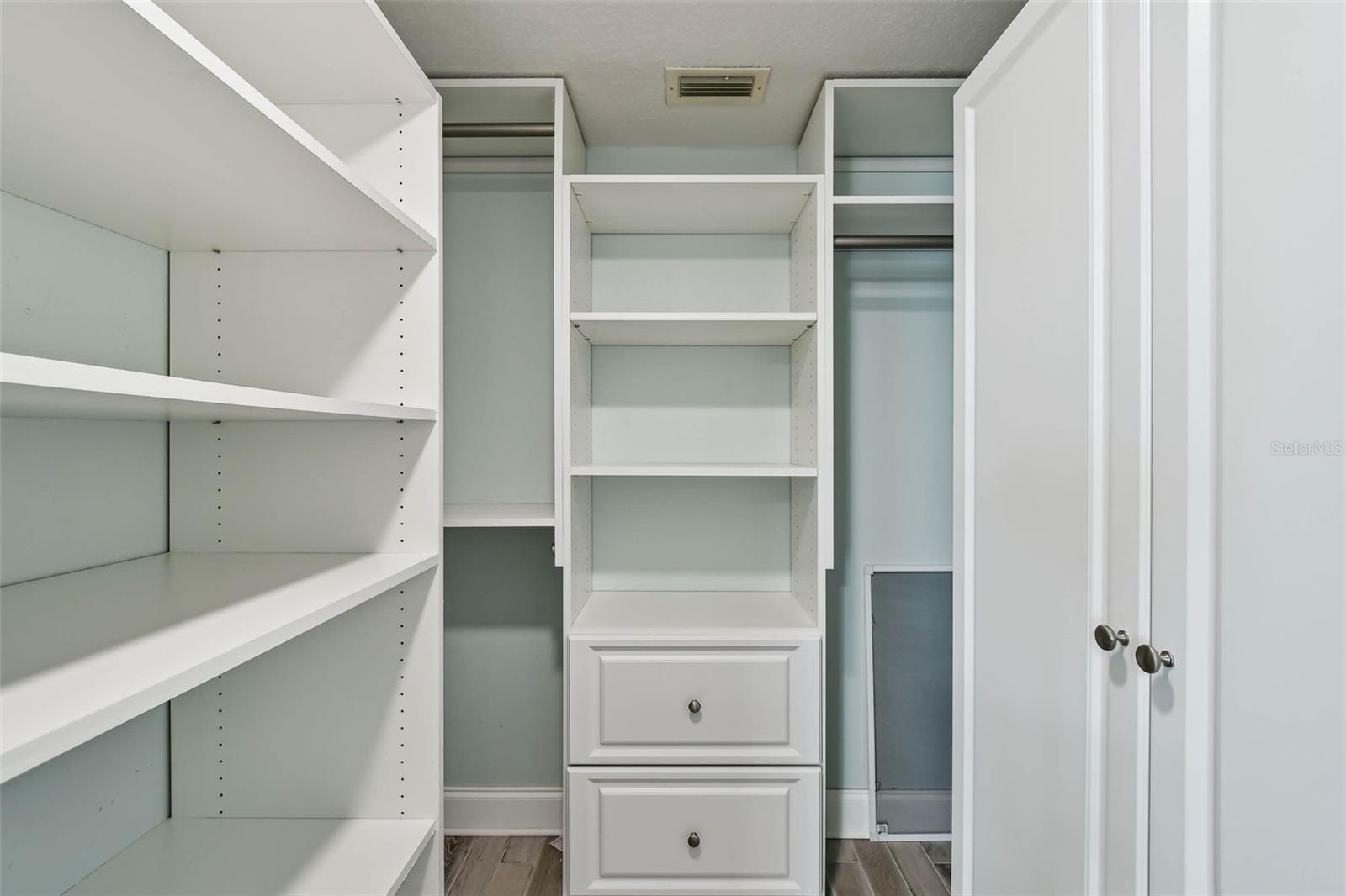Guest walk-in closet with built in organizer and safe