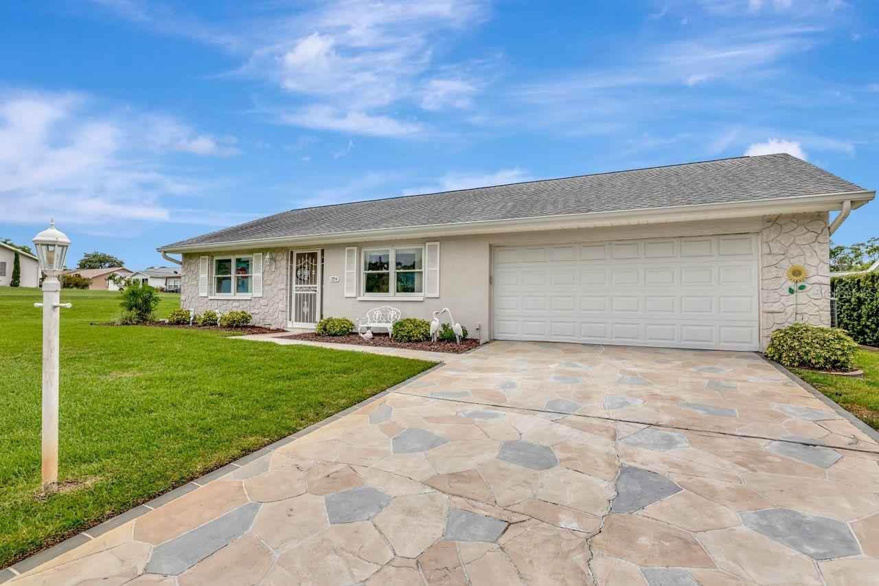 This home has a 2-car garage with a pavered stone driveway that could fit about 4 cars.