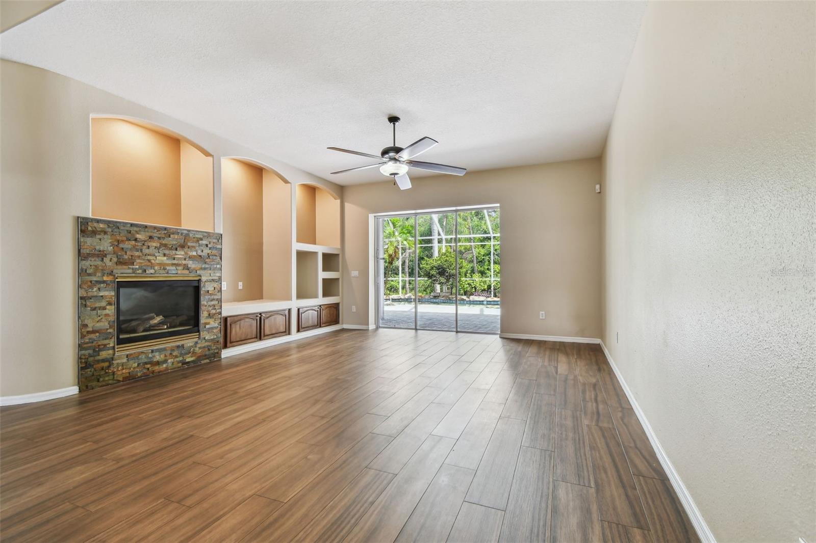 Family Room w/Gas Fireplace, Built-ins, & Tripple, Pocketing Glass Doors to Lanai