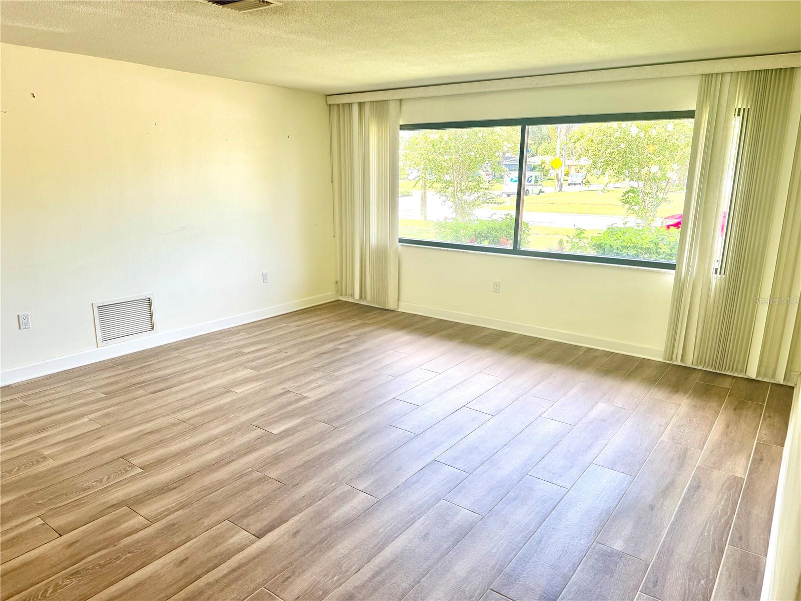 Large living room with upgraded double pane picture windows.