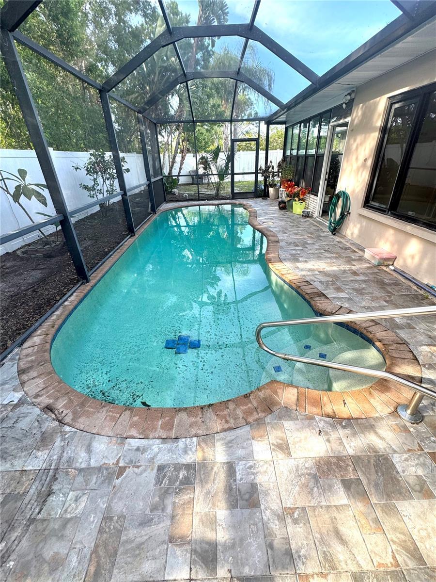 Beautiful newer pool with vaulted screen enclosure and tiled deck