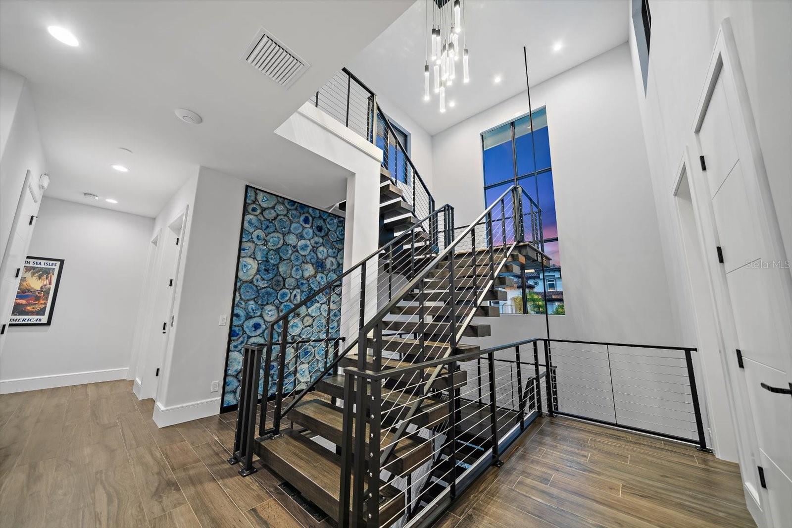Floating staircase enhanced by captivating blue agate feature wall.