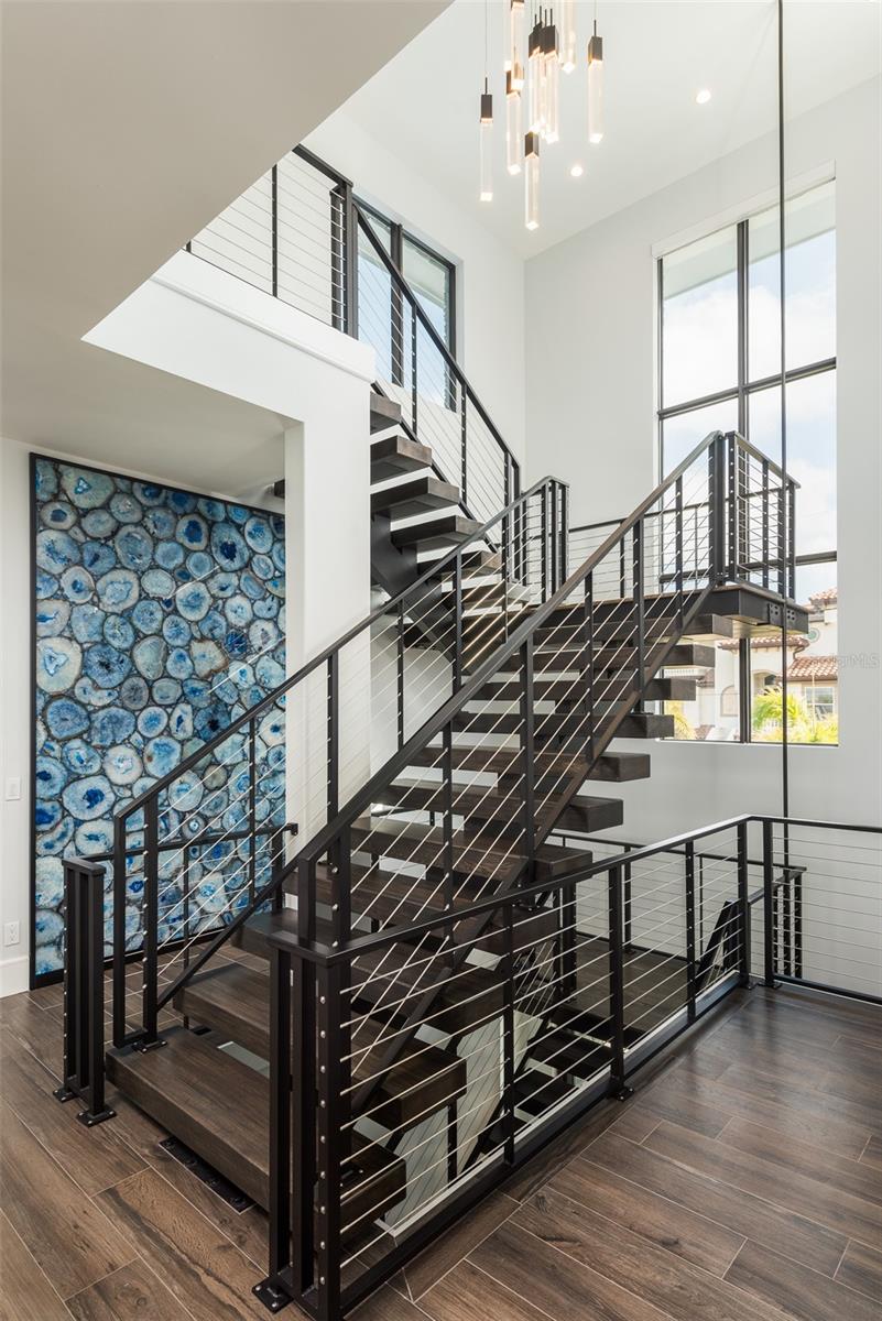 Floating staircase enhanced by captivating blue agate feature wall.