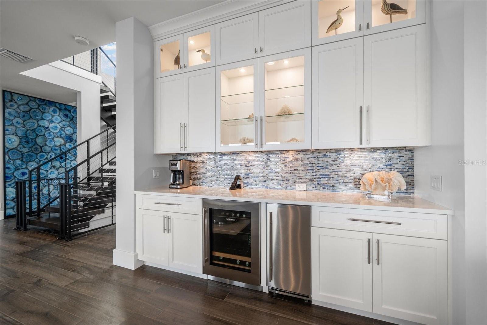 Additional built-in area with beverage refrigeration and icemaker flanked by custom cabinetry.