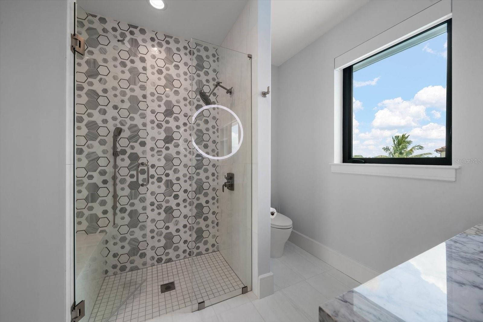 Ensuite bath in additional bedroom with intricate and trending tilework.