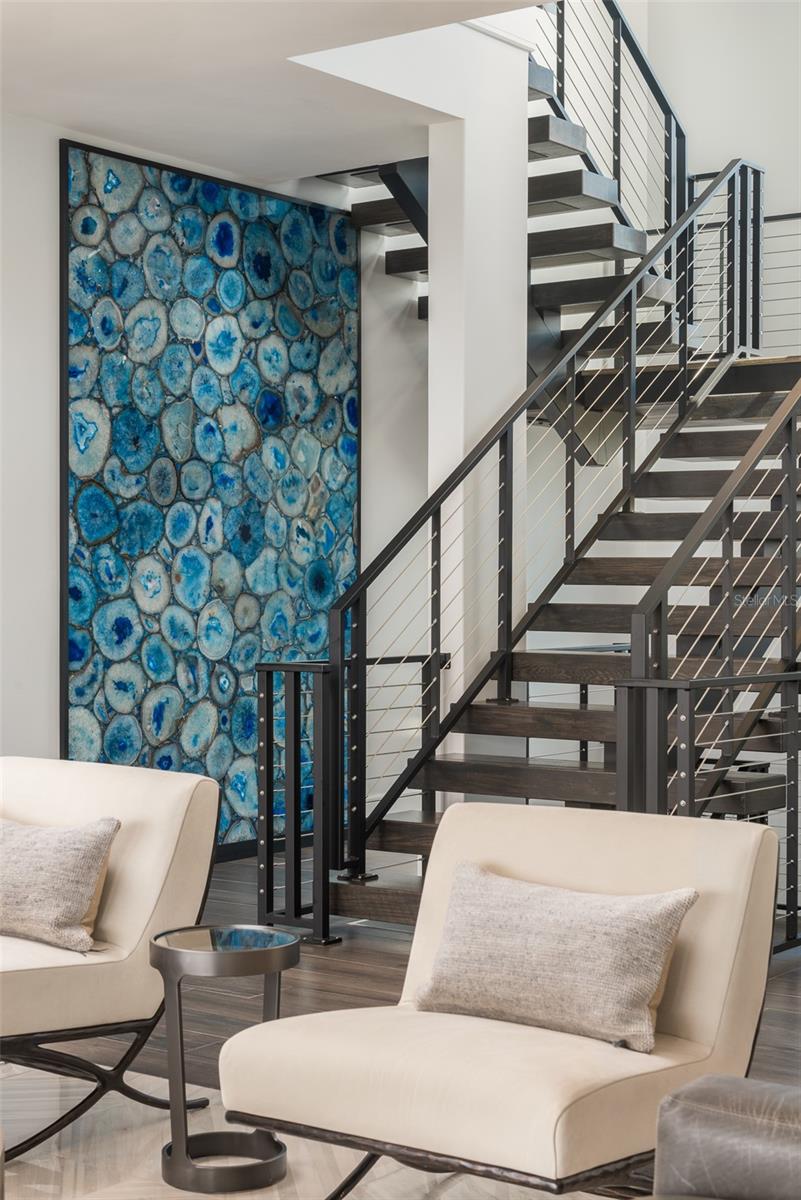 A dramatic entry enhanced by a gorgeous agate stone feature wall and attractive floating staircase.