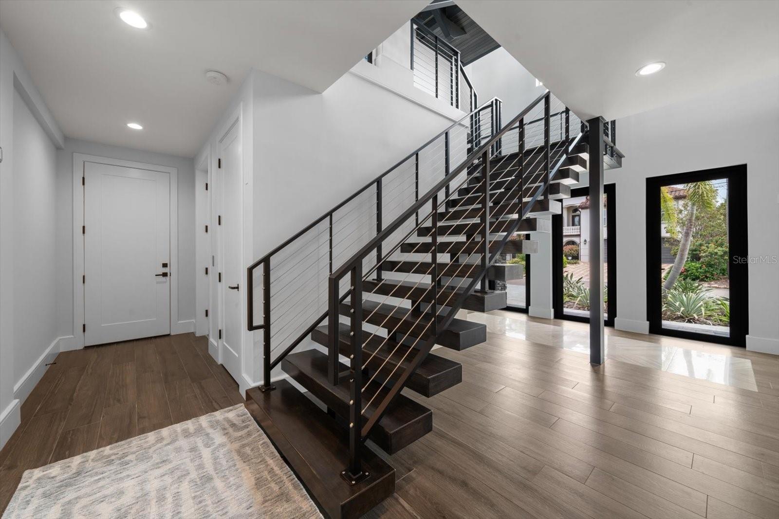 Ground level entry to elevator, split flight staircase, 2 garage areas with parking for up to 6 vehicles