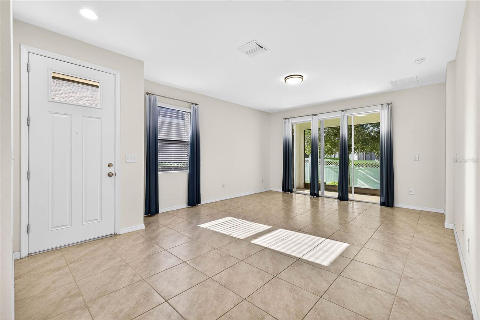 Tile flooring throughout the main living areas & bright/open sliding glass doors keeps sunlight coming in throughout the day